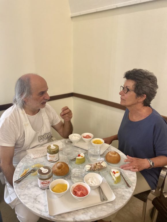 a man and a woman at a table of sicilian pastries