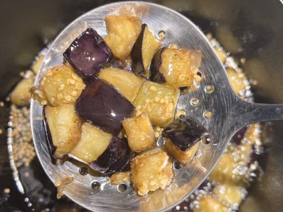 cubes of eggplant frying in extra virgin olive oil